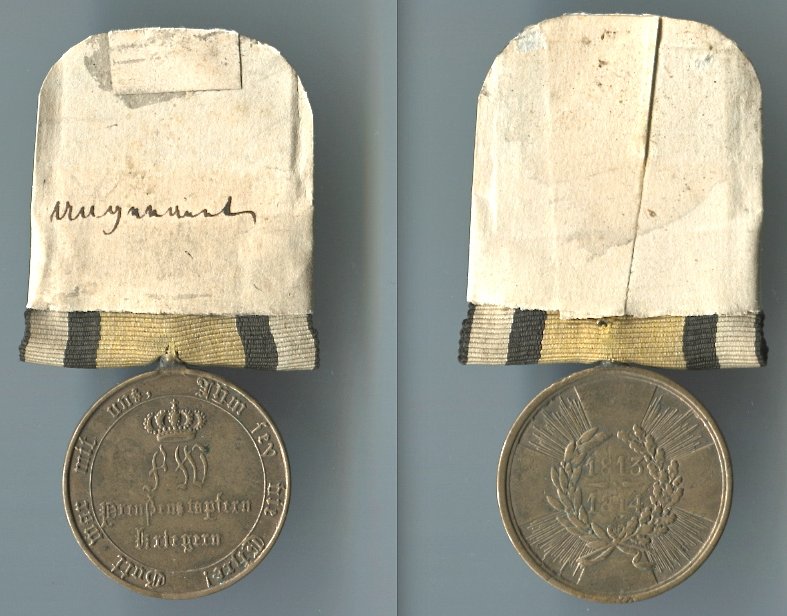 Abb. 36: Beispiel einer ursprünglich im Kirchspiel aufbewahrten Kriegsdenkmünze, hier eines unbekannten Soldaten. 1. Modell, 1813/14, mit runden Armen; 17,1 g mit Band und Schildchen.
